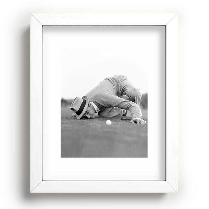 Eye to the ground on the 18th hole; golfing man eyes ball to measure distance to hole vintage black and white portrait photograph - photography - photographs poster Framed Art Print Gallery Image 103